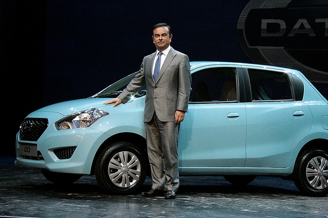 Former Nissan CEO Carlos Ghosn stands next to a Datsun GO.